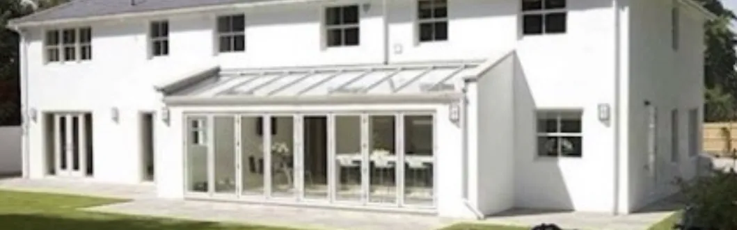 White rendered house with a glazed rear extension and bi-fold doors